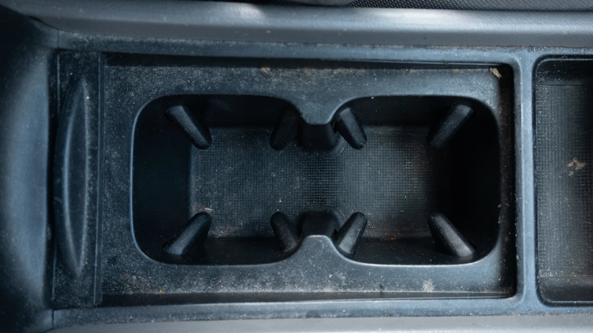Dust and debris in cupholders before interior detailing